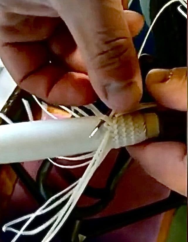 Showing a knife handle being braided by hand.