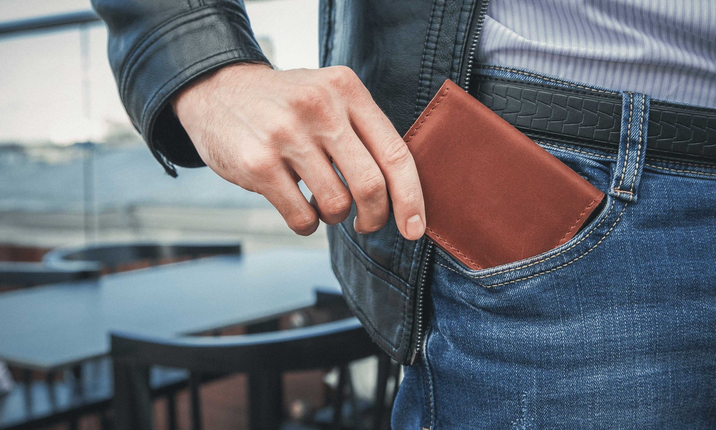 Man putting slim fromt pocket Argentine cowhide leather into front left pocket.