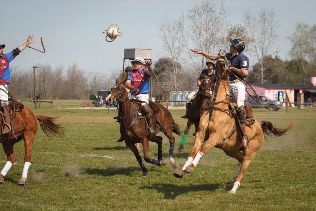 Four pato players on horses.