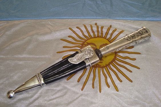A Gaucho knife laying on top of a sun flag.