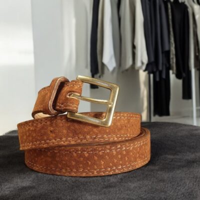 The stylish women’s Capybara leather belt with a brass buckle, featuring a sleek, tapered design and hand-stitched colored accents, ideal for a polished, fashionable look.
