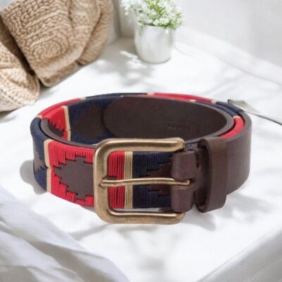 A close-up of an Argentine leather polo belt with red, navy, and white embroidery.