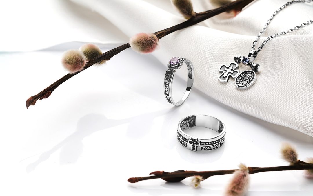 A display of silver and gold rosary rings, each featuring intricate designs and perfect for both spiritual and stylish wear.
