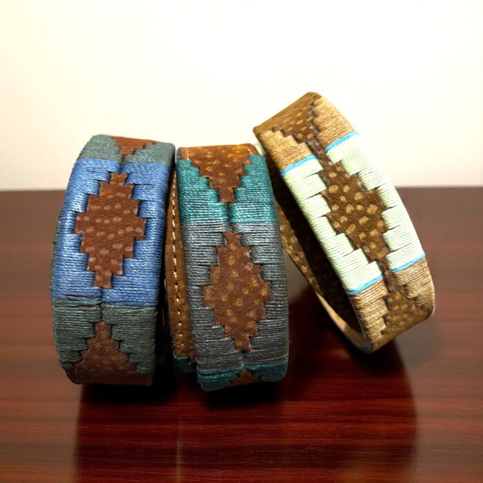 Group of three Carpincho embroidered belts with colorful threads and brown leather details, showcasing Argentine craftsmanship