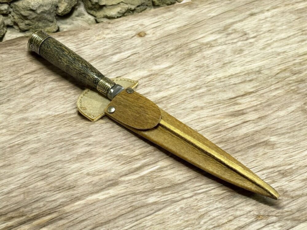 Handmade Gaucho knife with wooden handle, alpaca details, and rawhide sheath