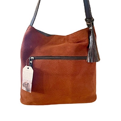 Suela carpincho leather hobo bag with front zipper and dark leather tassel.