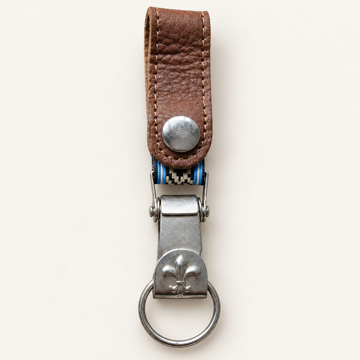 Brown leather belt clip keychain with fleur-de-lis motif and Guarda Pampa band edged in sky blue and white.