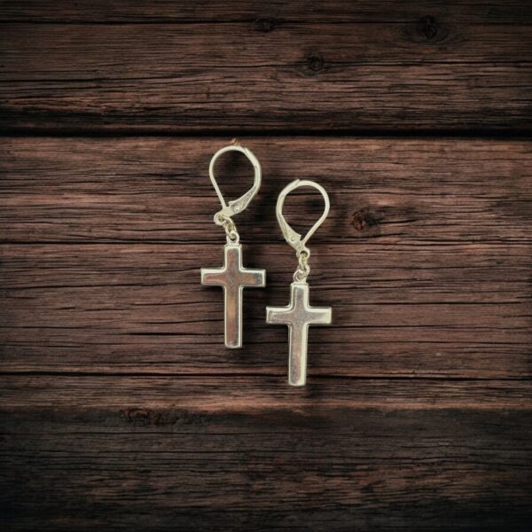 Close-up photo of sterling silver cross dangle earrings showing fine craftsmanship and shine