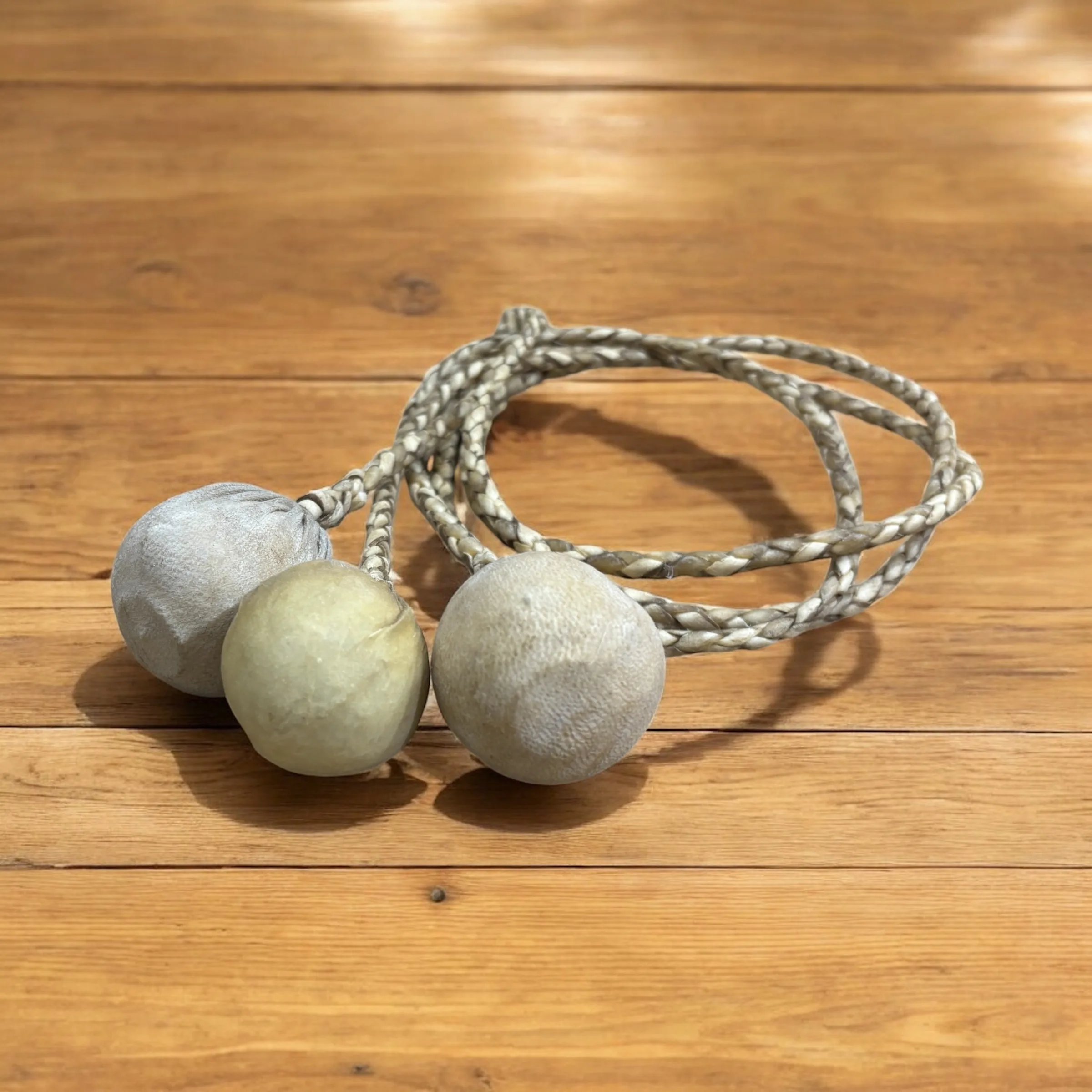 Close-up of Handcrafted Argentine Leather Boleadoras on rustic wooden table