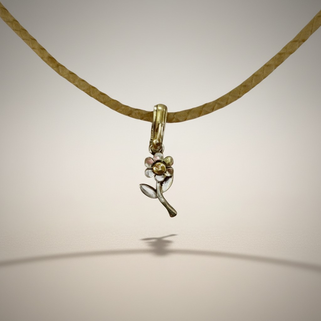 Sterling silver flower pendant with gold center and bail on braided raw leather choker