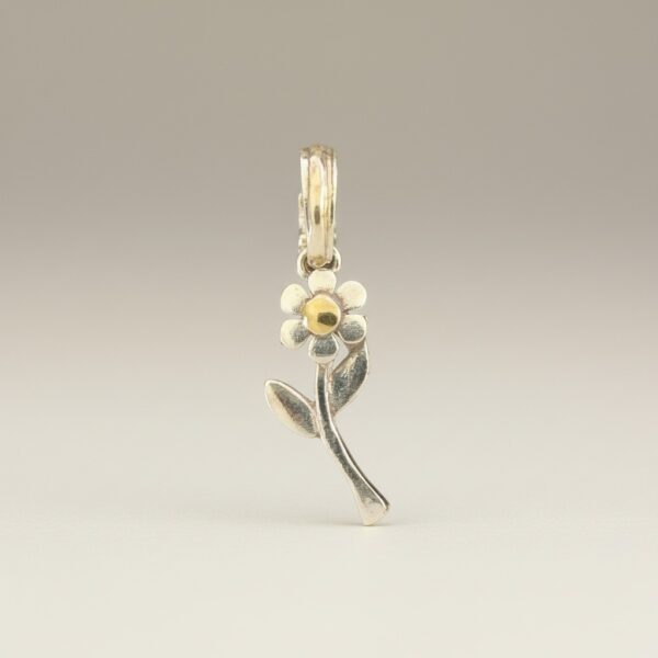 Sterling silver flower pendant with stem and leaves, yellow gold center and bail