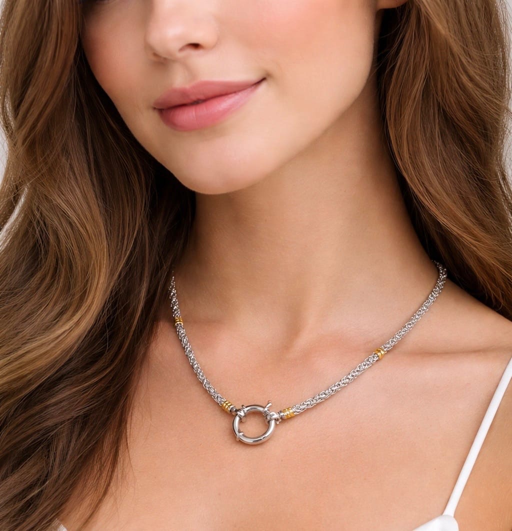 Close-up of a model wearing a sterling silver chain with 18kt gold accents, highlighting its braided links and refined craftsmanship
