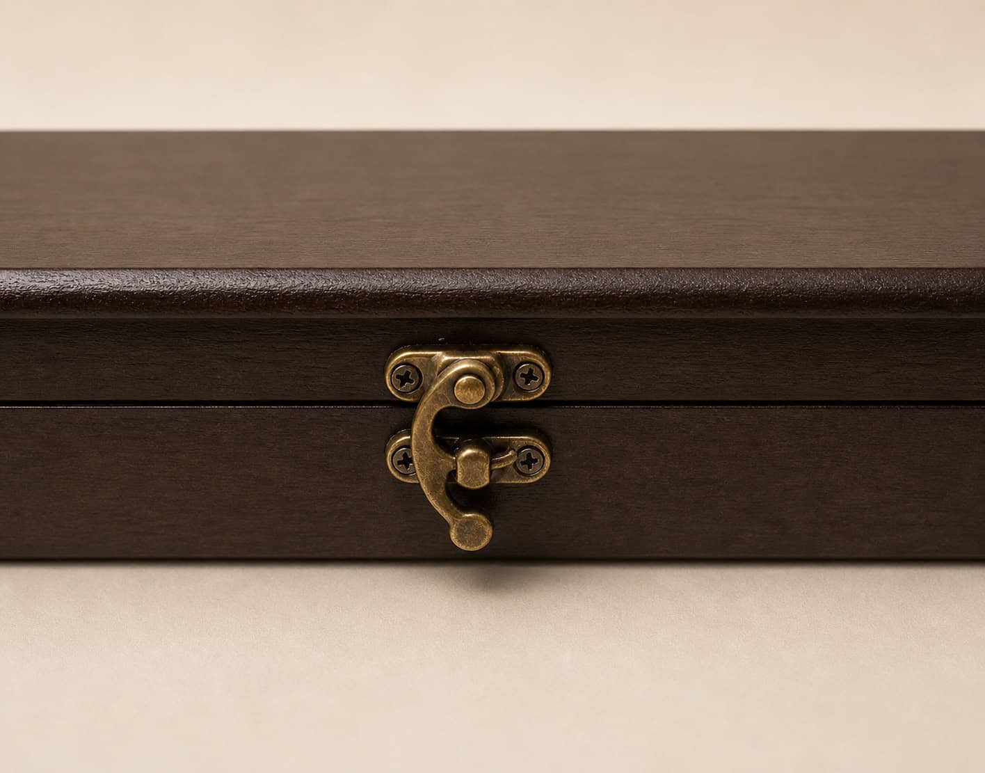 Close-up of antique brass clasp on dark wooden knife presentation box