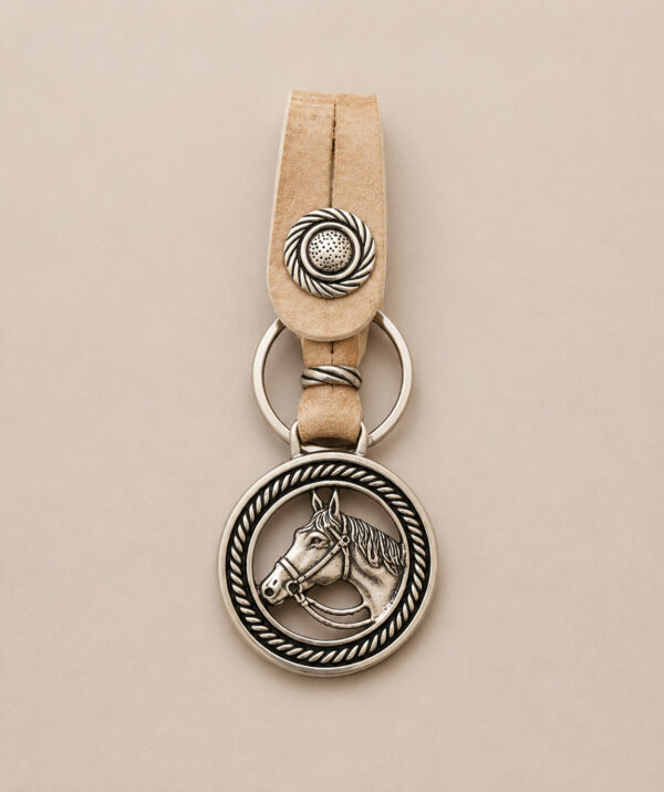Handmade Argentine keyring featuring an Alpaca silver horse head medallion and genuine rawhide leather.