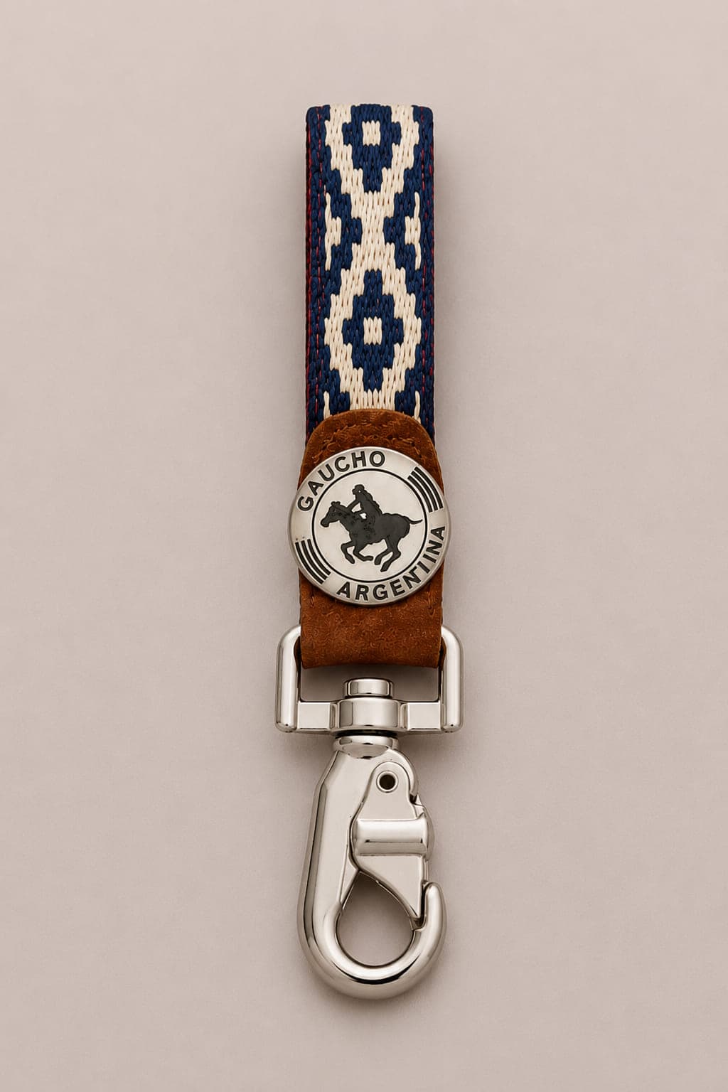 Handcrafted Argentine polo key ring featuring a blue woven Guarda Pampa strap, genuine capybara leather, a Gaucho Argentina polo medallion and a polished silver-tone swivel clip.