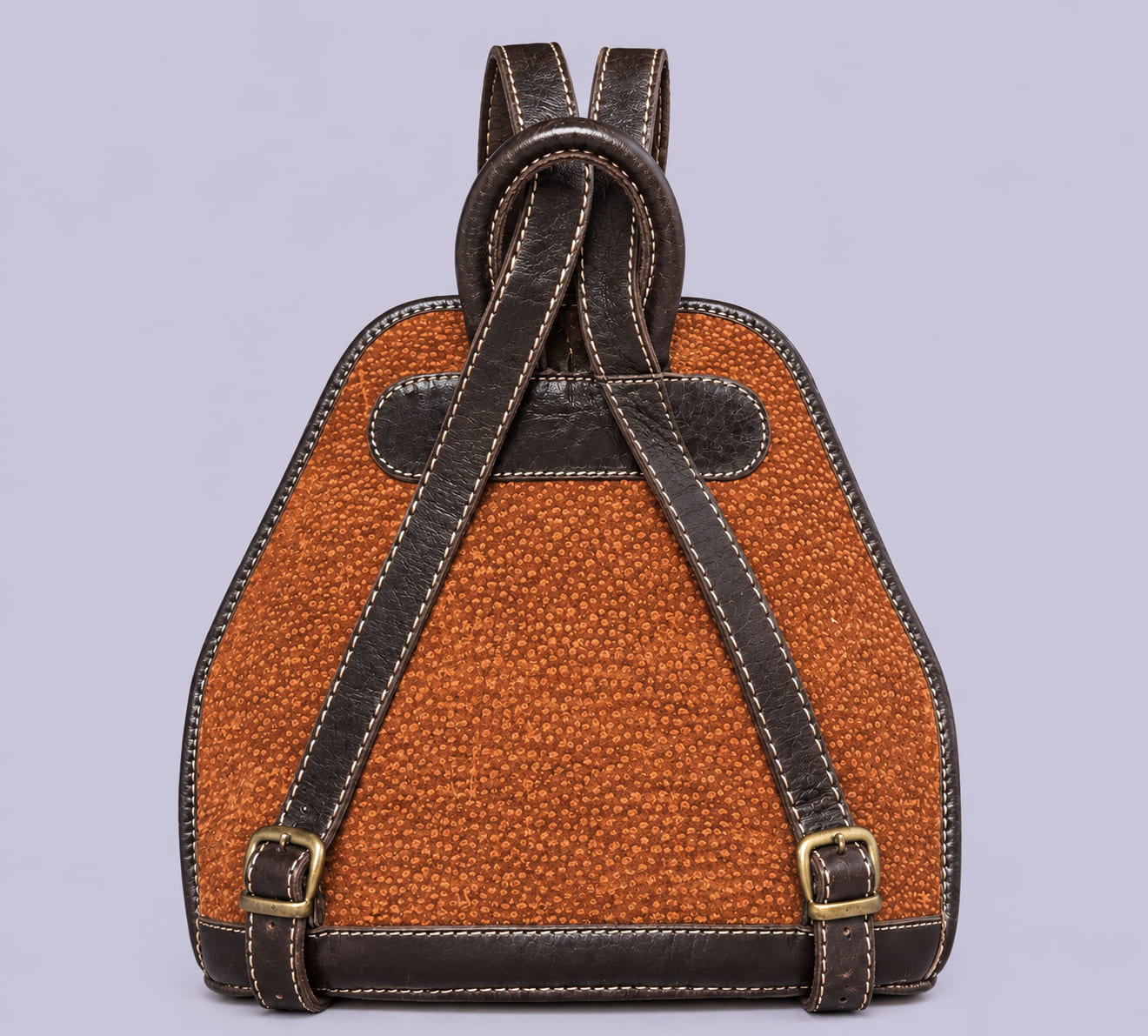 Back view of a handmade capybara leather backpack with adjustable leather shoulder straps, crafted in Argentina.