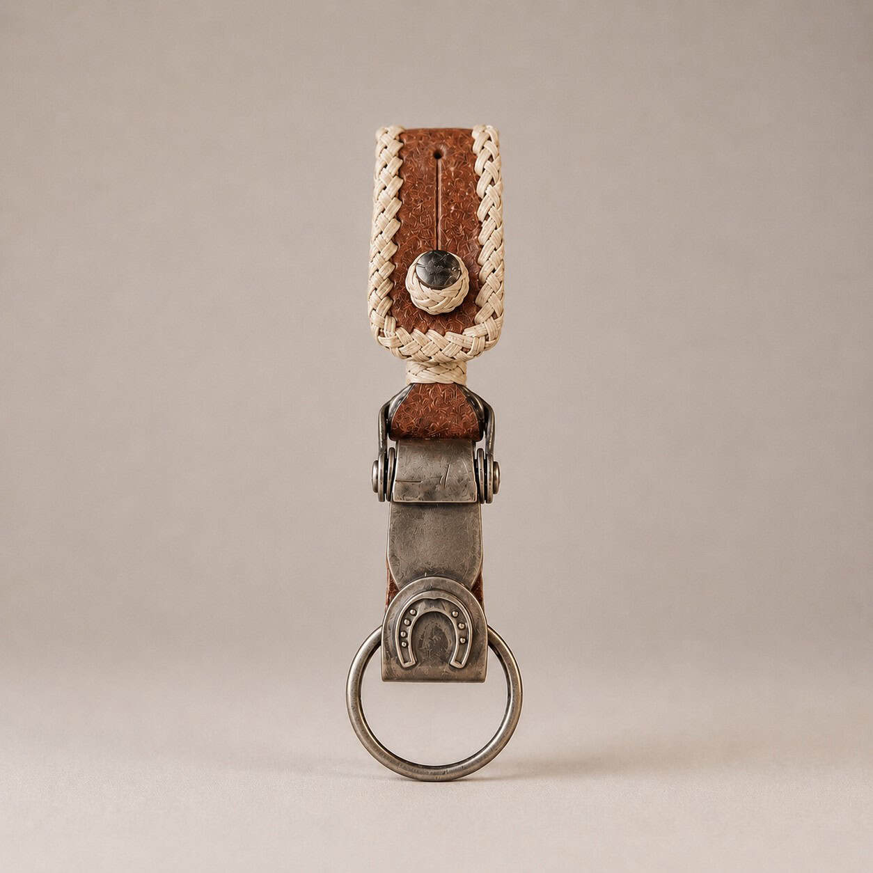 Argentine capybara leather keychain with horseshoe motif and hand-braided rawhide detail