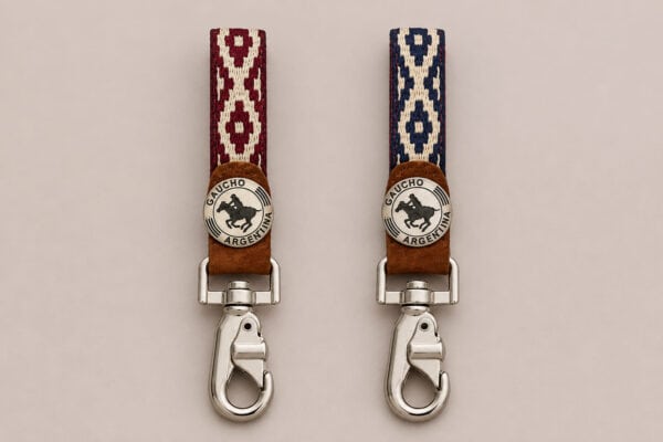 Two handcrafted Argentine polo key rings displayed side by side, one with a red Guarda Pampa weave and the other with a blue pattern. Both feature genuine capybara leather, a Gaucho Argentina polo medallion and polished swivel clips.