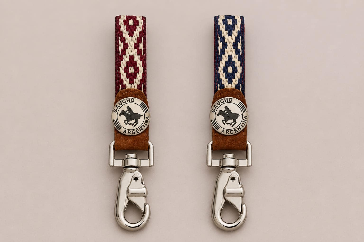 Two handcrafted Argentine polo key rings displayed side by side, one with a red Guarda Pampa weave and the other with a blue pattern. Both feature genuine capybara leather, a Gaucho Argentina polo medallion and polished swivel clips.