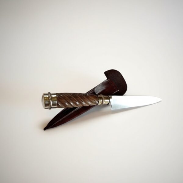 Handmade gaucho knife crossed over chocolate brown leather sheath
