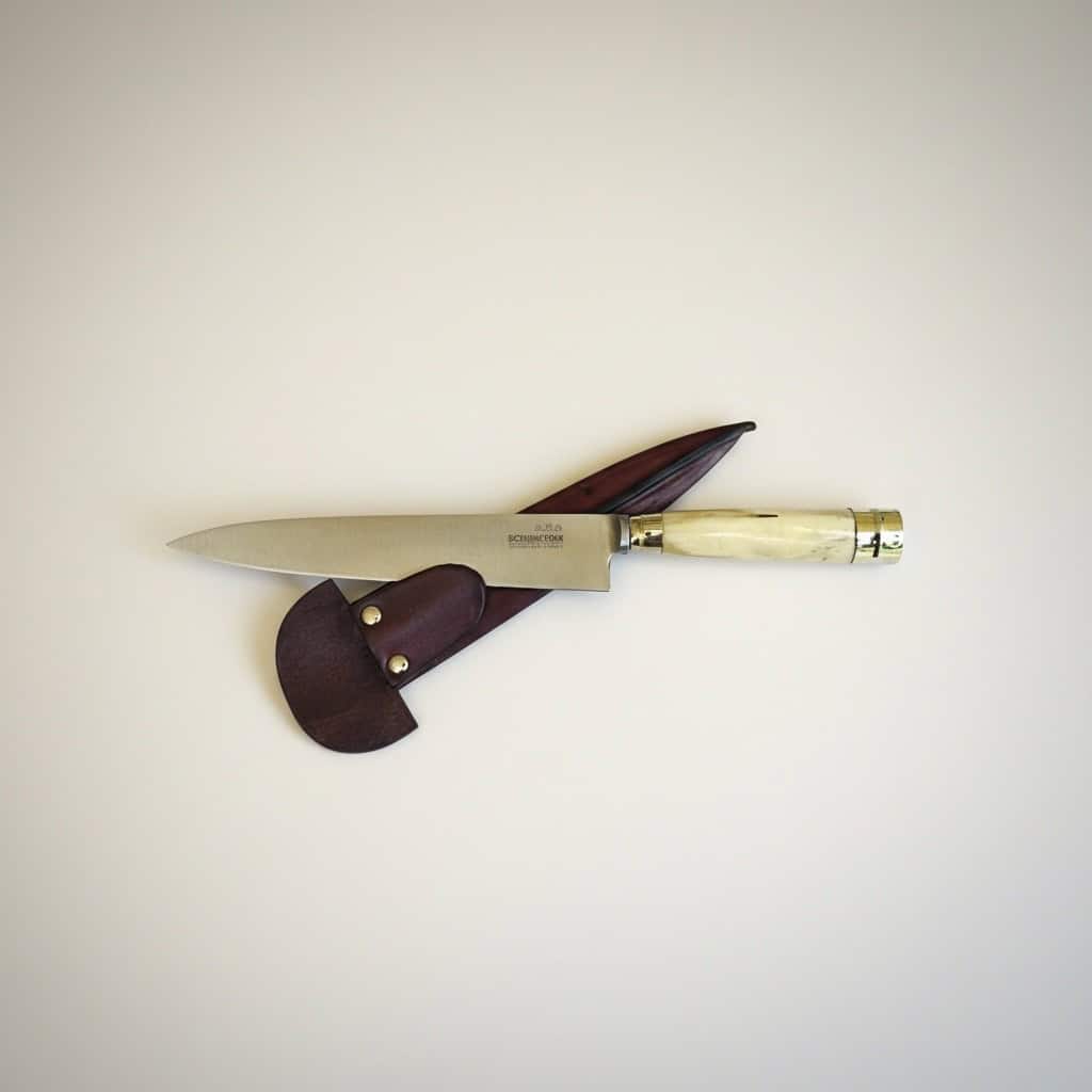 Handmade staghorn gaucho knife crossed over chocolate brown leather sheath