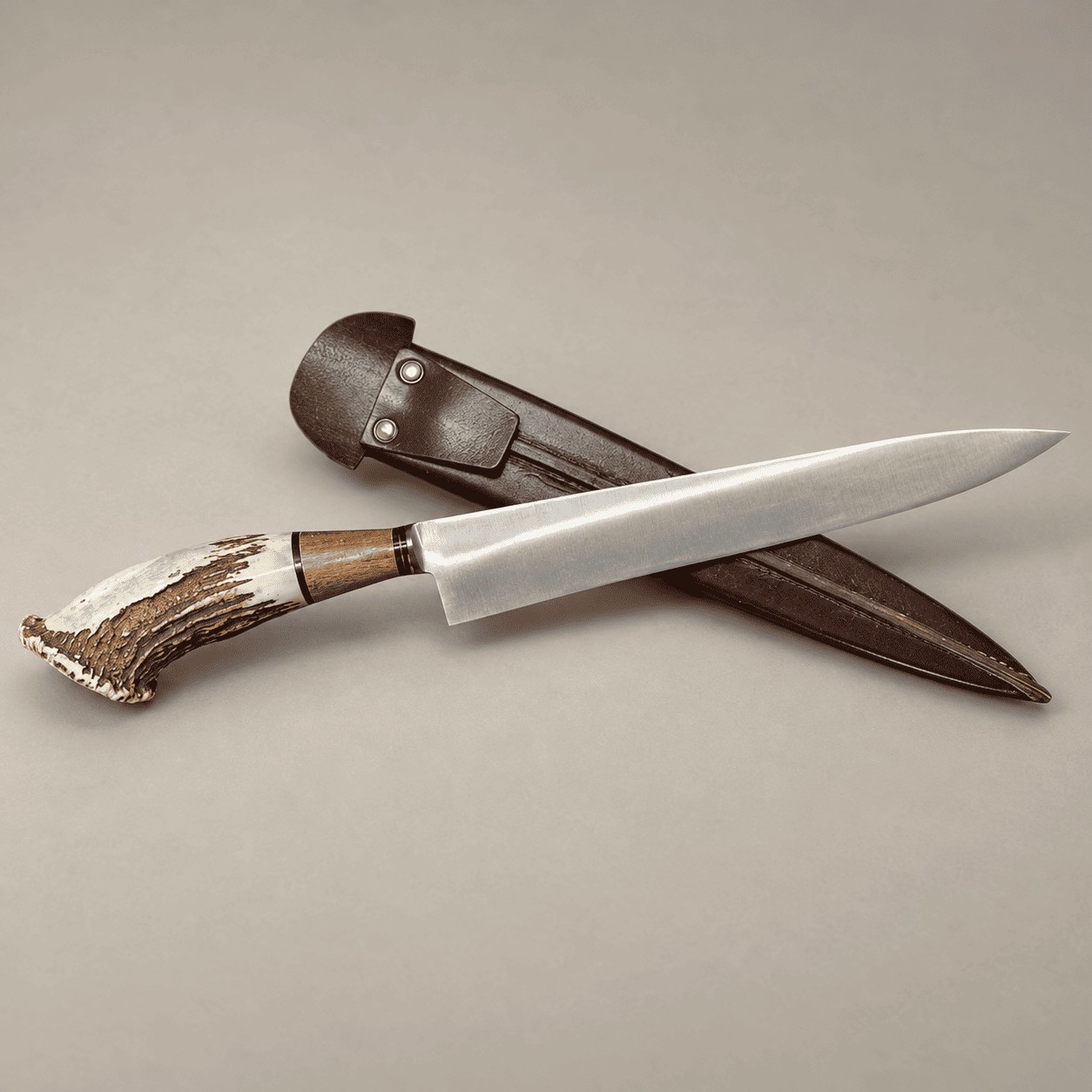 Argentine gaucho knife with a curved staghorn and hardwood handle, resting across a brown leather sheath.