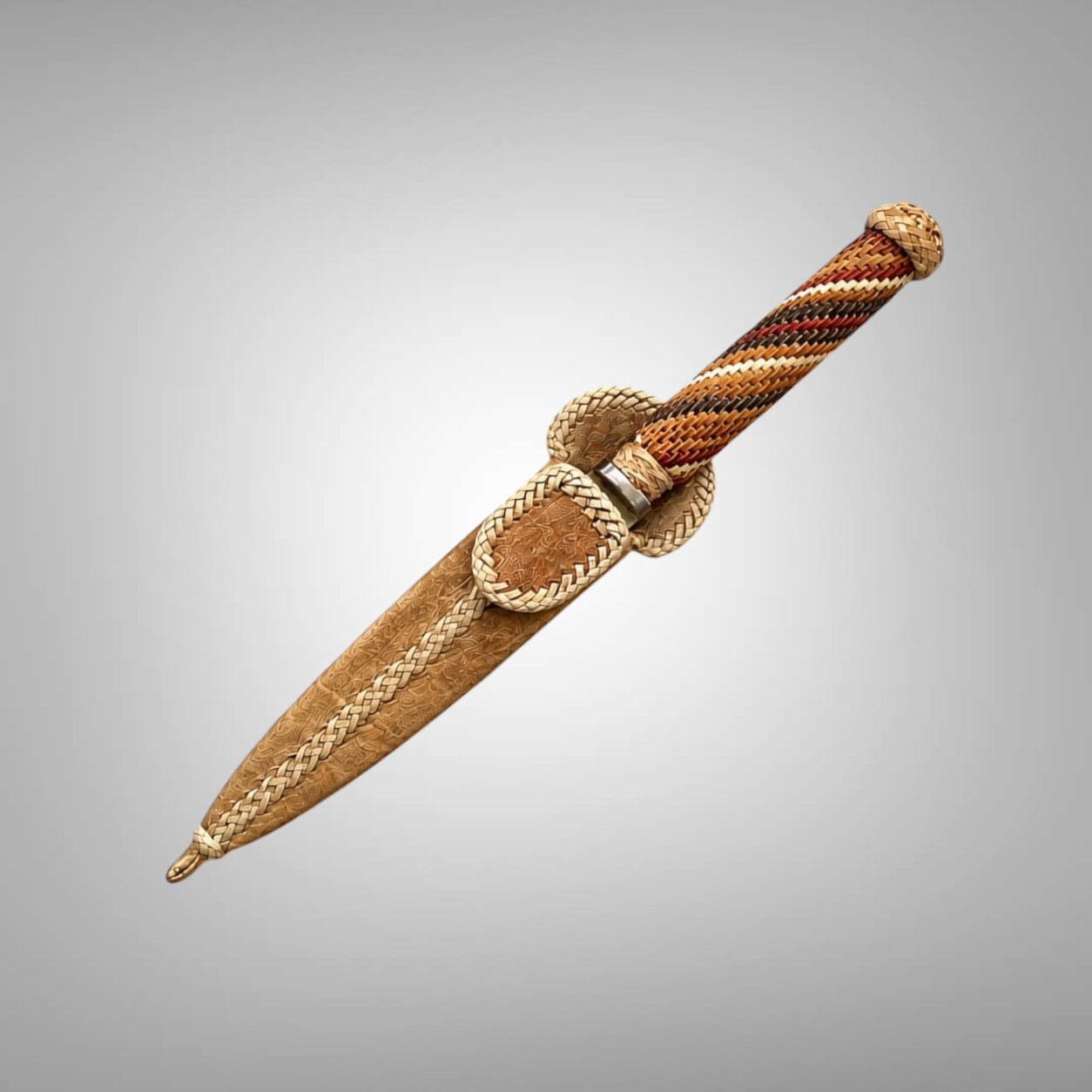 Sheathed Argentine gaucho knife set diagonally against a soft gray background, with a hand-braided rawhide handle in tan, rust, ivory and charcoal.