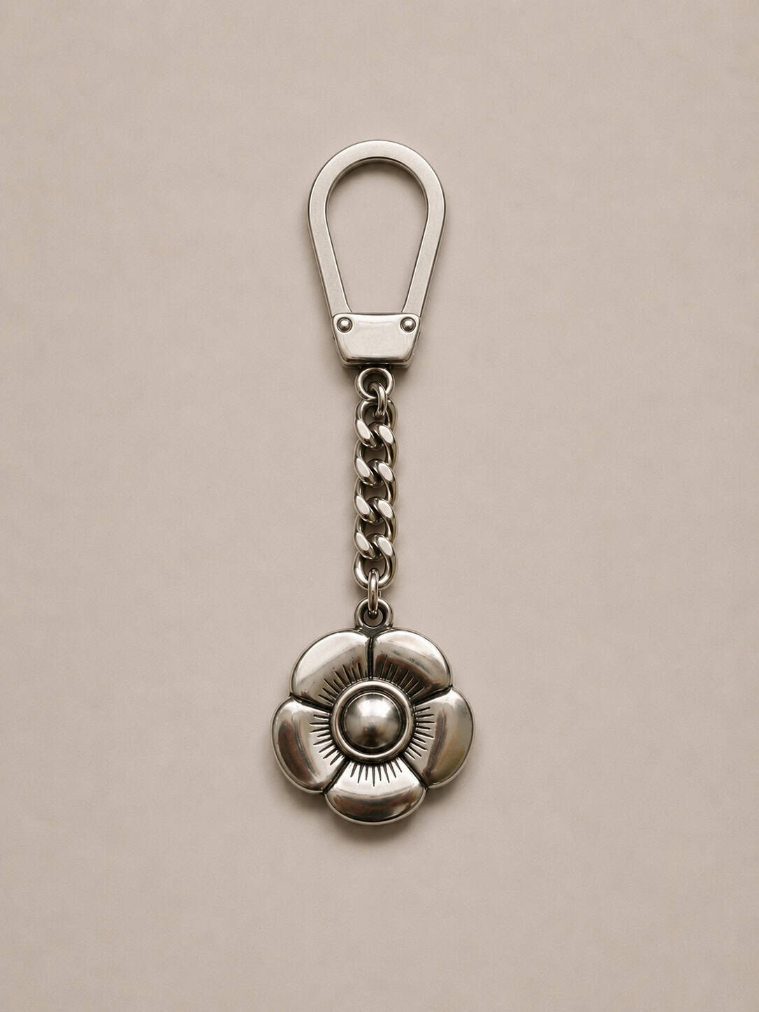 Handcrafted Argentine pansy blossom key ring featuring a polished metal flower charm and flat silver clip.
