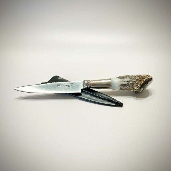 Handmade Argentine gaucho knife with natural deer antler handle resting on black leather sheath