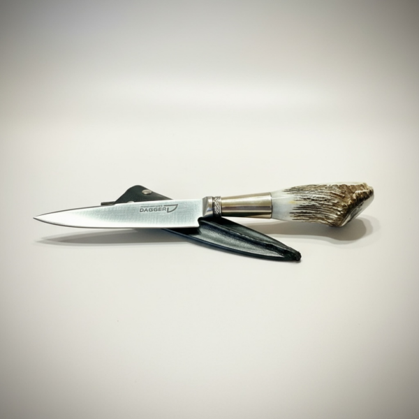 Handmade Argentine gaucho knife with natural deer antler handle resting on black leather sheath