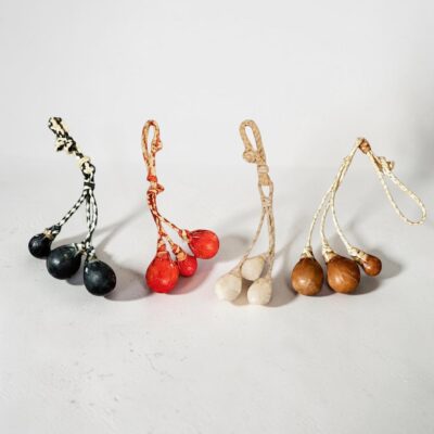 Handmade rawhide mini boleadoras keyrings in four color variations, artisan crafted in Argentina.
