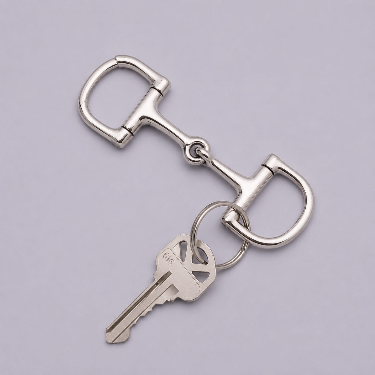 Heavy chrome D-ring snaffle bit keychain holding a key on one split ring.