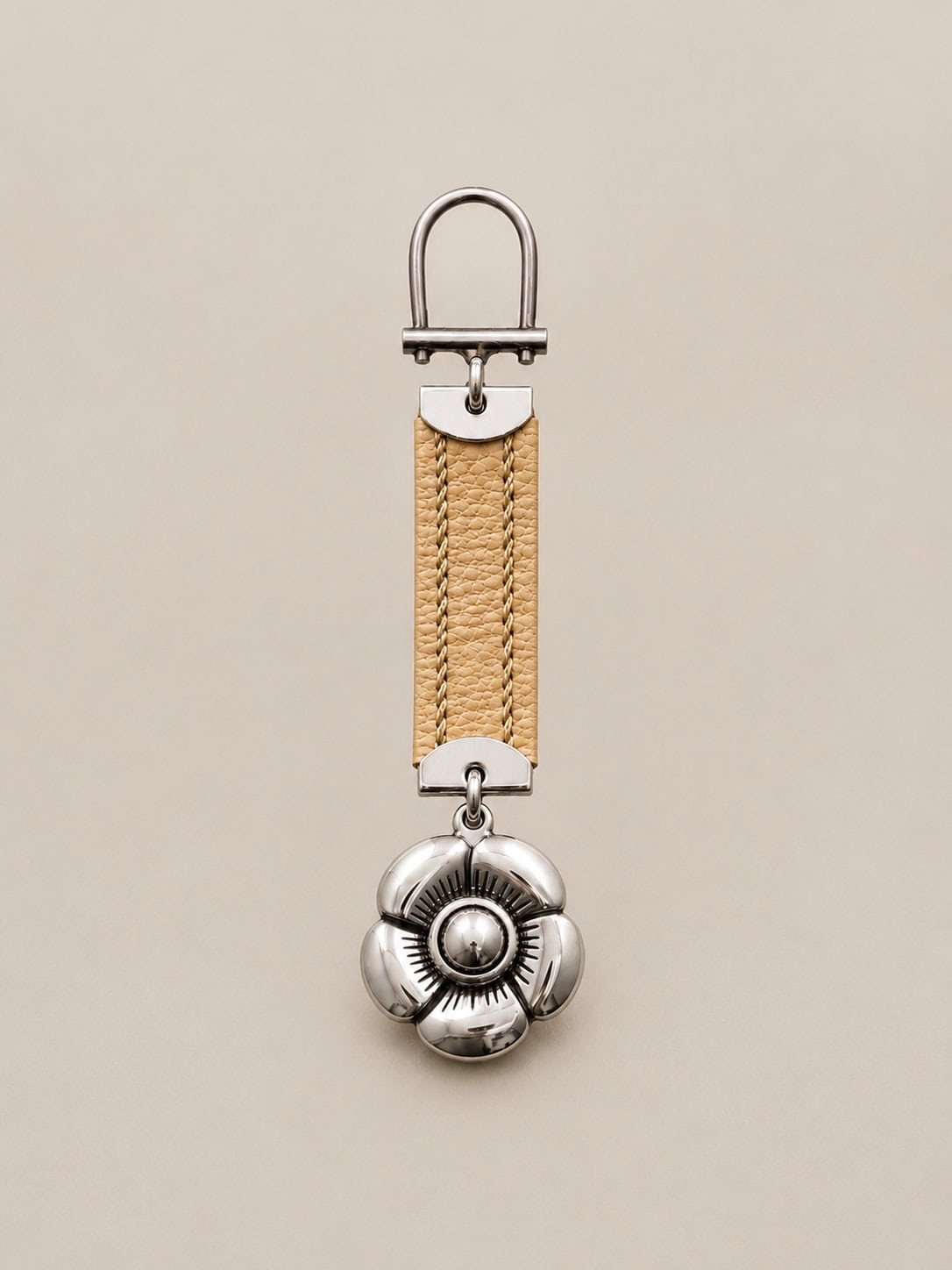 Handmade Argentine pansy blossom keychain featuring a sterling silver-plated alpaca flower and natural raw leather strap.