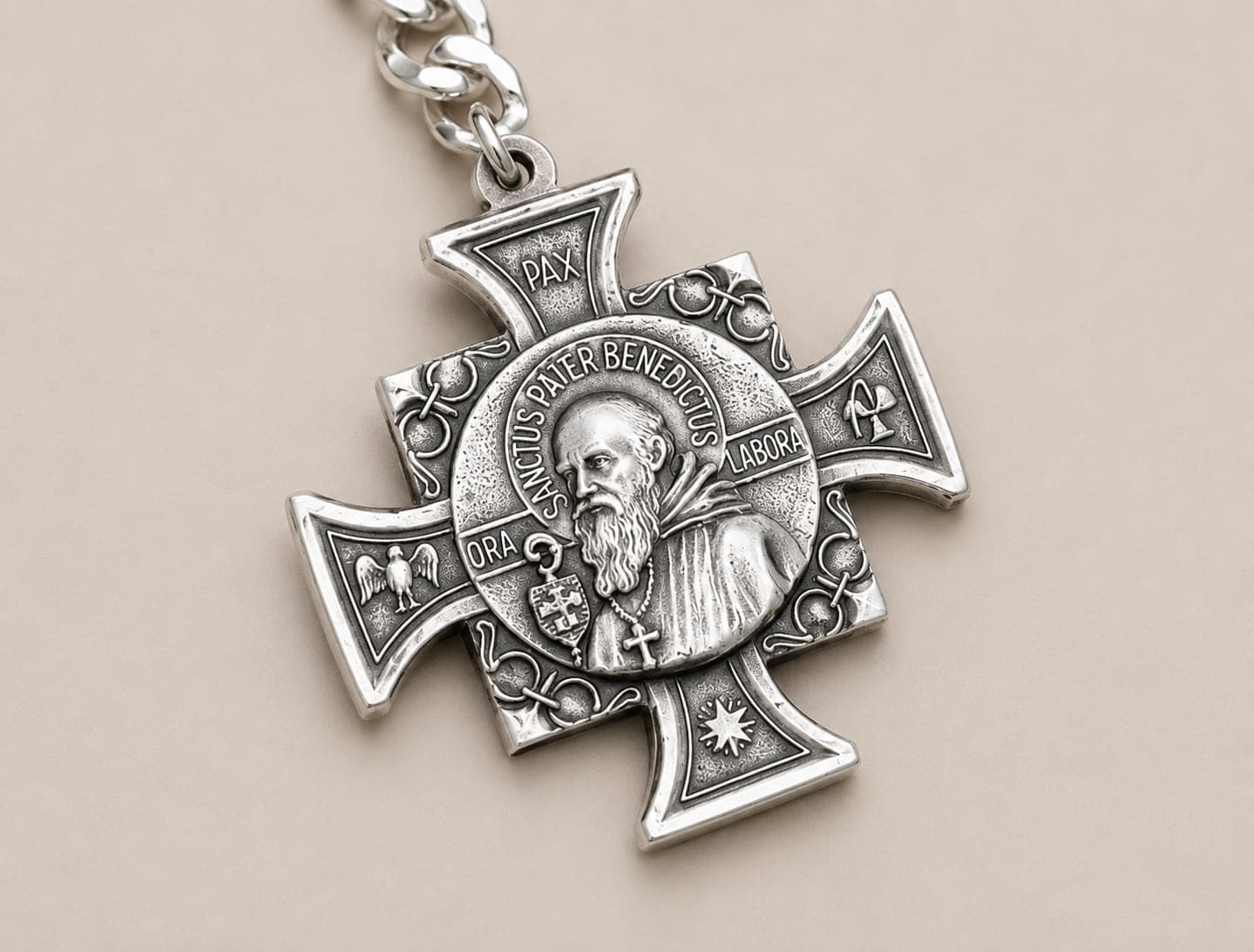 Close-up of a handmade Saint Benedict cross keychain in alpaca silver with a sterling silver finish.
