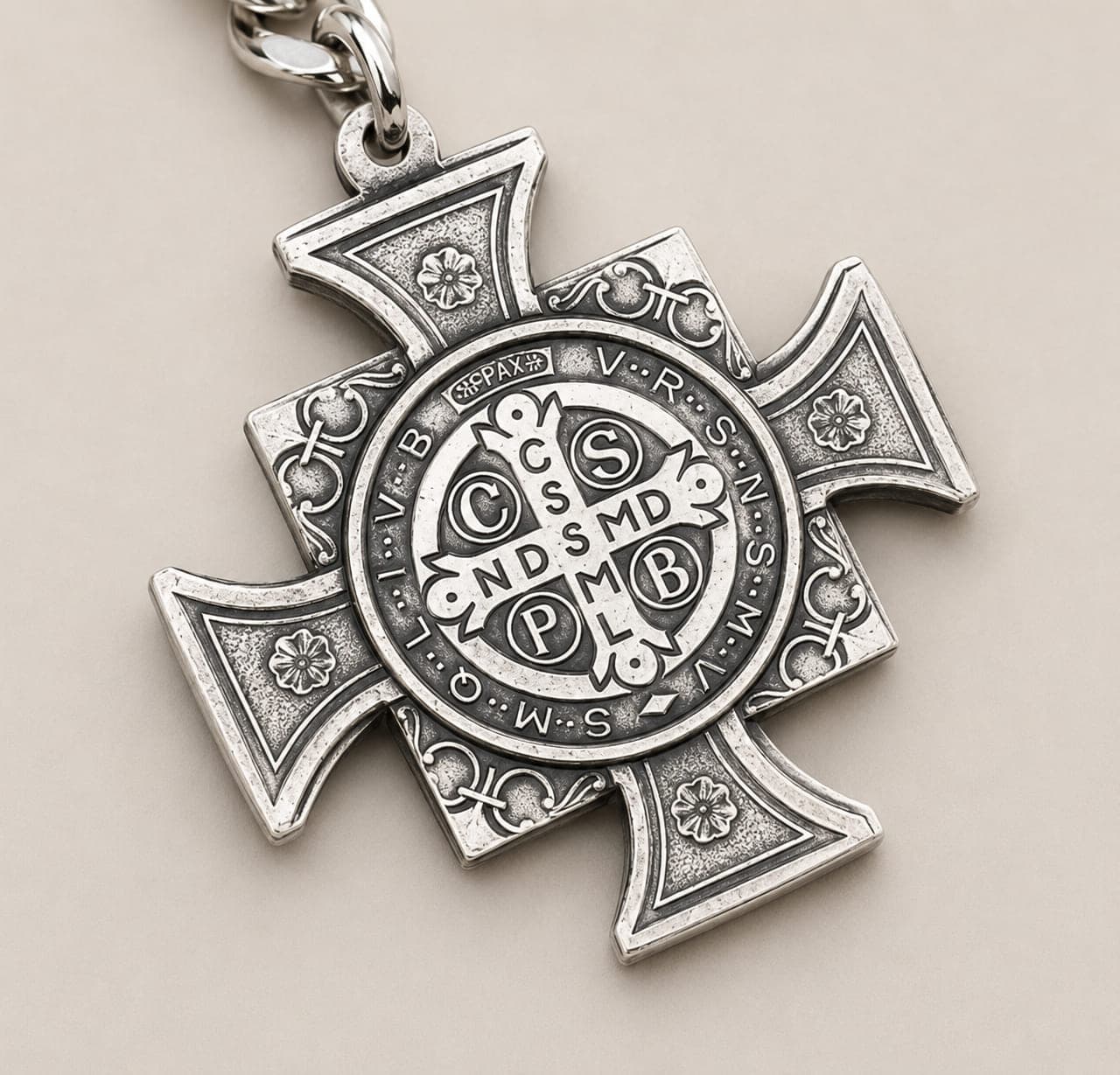 Close-up of the Saint Benedict cross keychain showing the engraved medal symbols and detailed alpaca silverwork.