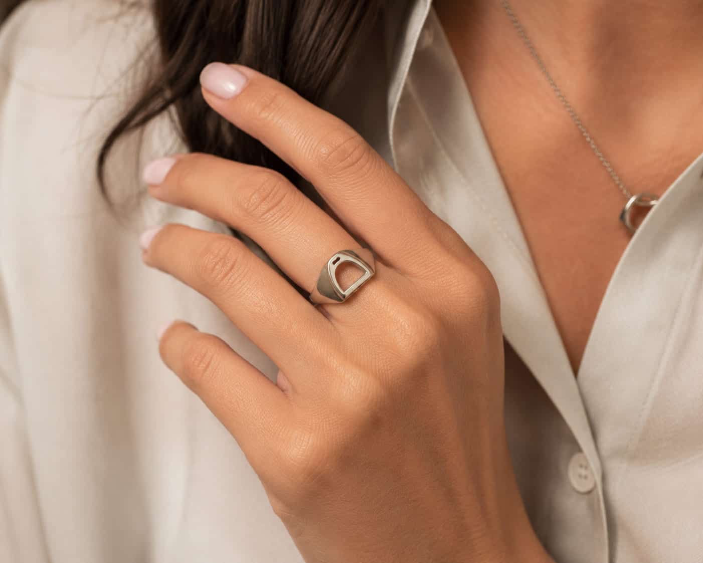 Woman wearing the handcrafted sterling silver Stirrup Ring by Pieces of Argentina, inspired by the iconic riding stirrup.