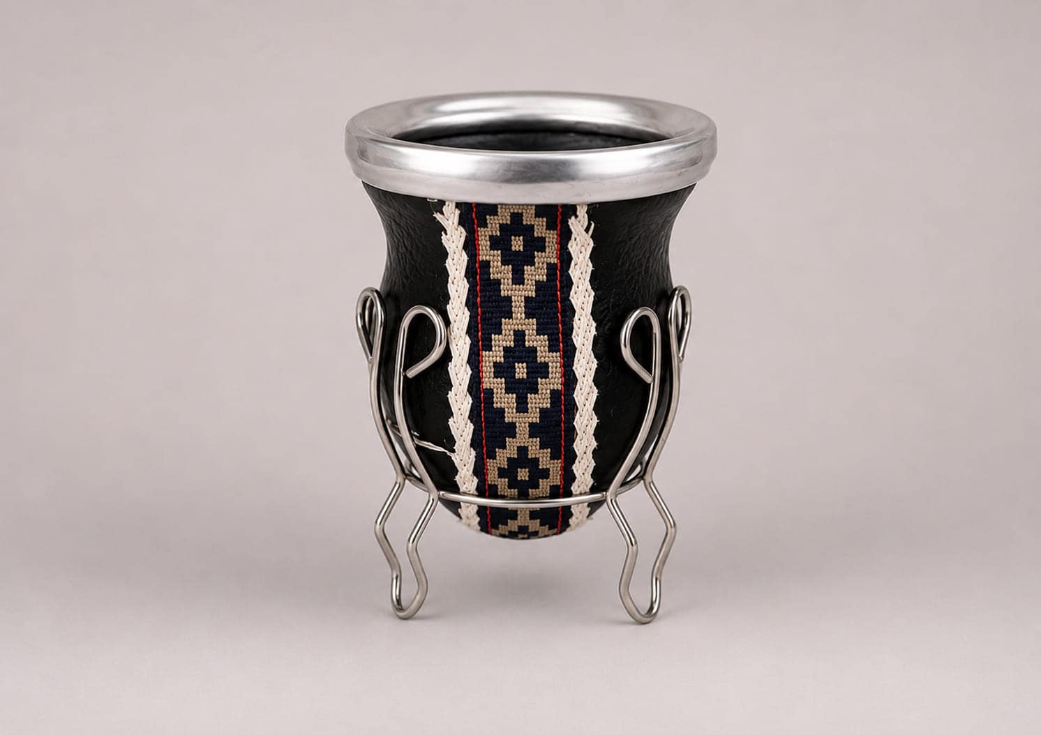 Traditional Argentine mate gourd handcrafted in genuine black leather with an alpaca silver rim, Guarda Pampa ribbon and matching metal stand.