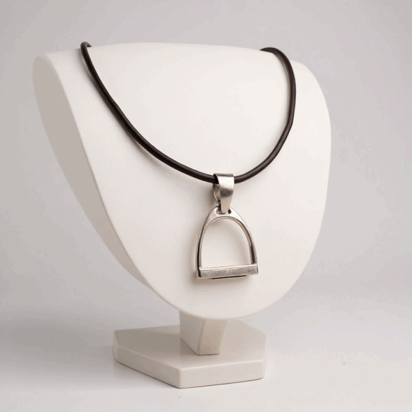 Oversized Iron Riding Stirrup pendant made of sterling silver on a dark leather choker, displayed on a white necklace stand