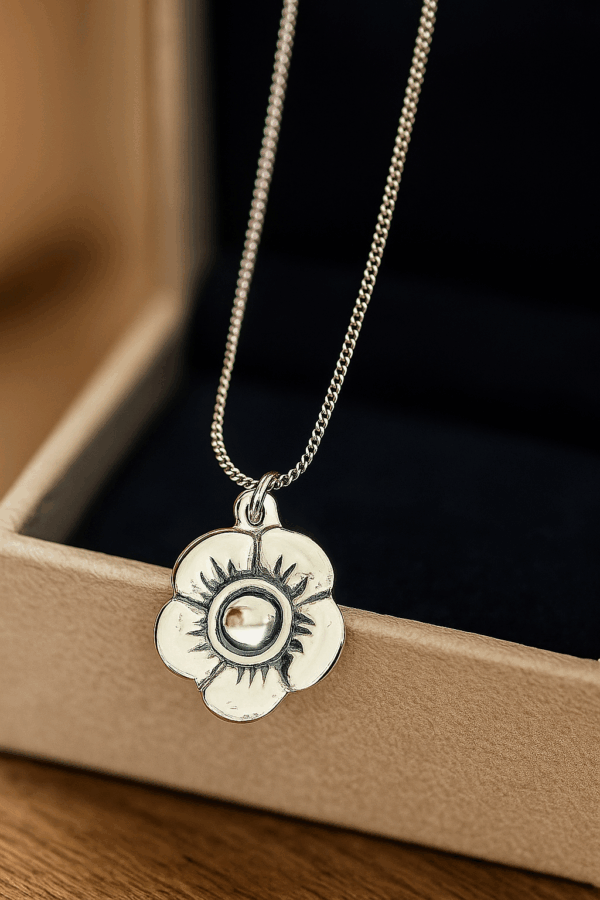 sterling silver flower pendant on a fine chain, elegantly displayed hanging from an open jewelry box