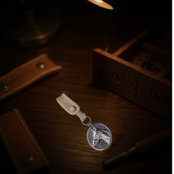 The 925 Silver Plated Alpaca Horse Head Keychain with Rawhide Leather Loop isolated on gallery background.