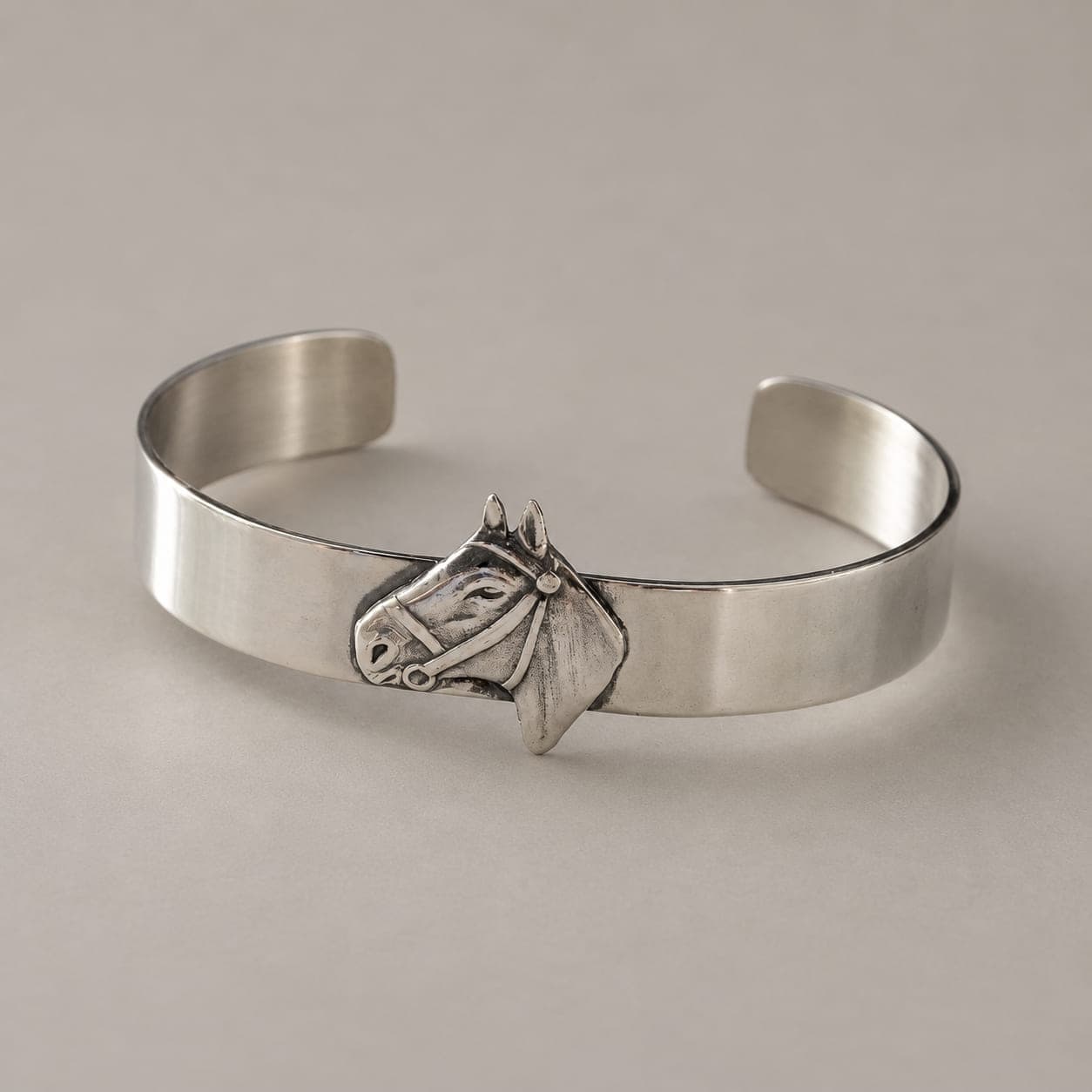 Alpaca cuff bracelet finished in sterling silver, shown upright with a bridled horse head in relief